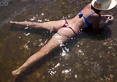 Adult woman enjoys her trip at the Volga beach and goes naked