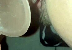 Wife ties up her man and takes turns using a massive dark colored dildo to fuck his creamy load
