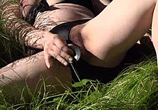 A milf with natural tits has sex with a big dildo outdoors