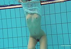 White-dressed tight hairy babe Katy Soroka swimming underwater in pool.