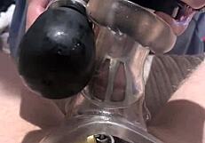 A BDSM slave is teased with a caged cock in a fleshlight.