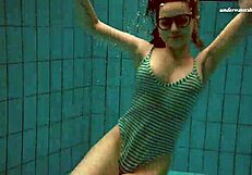 Petite brunette beauty Dasha swims in the lake