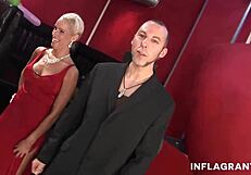 A blonde gives a blowjob and fingering to a guy while being fucked by a gangbang